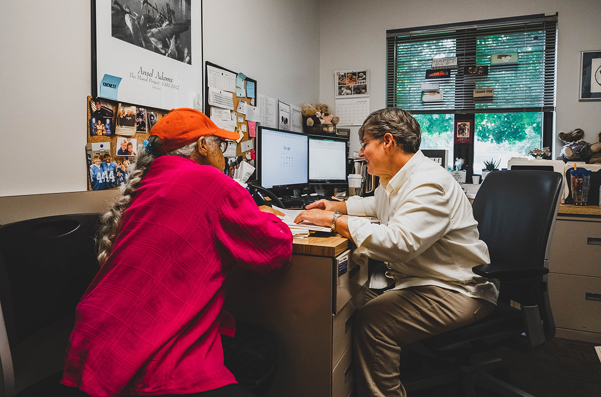 A woman helping another woman with paperwork